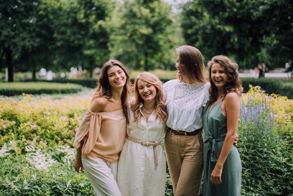 A joyful group of women standing together in a sunny park, symbolizing friendship and togetherness.