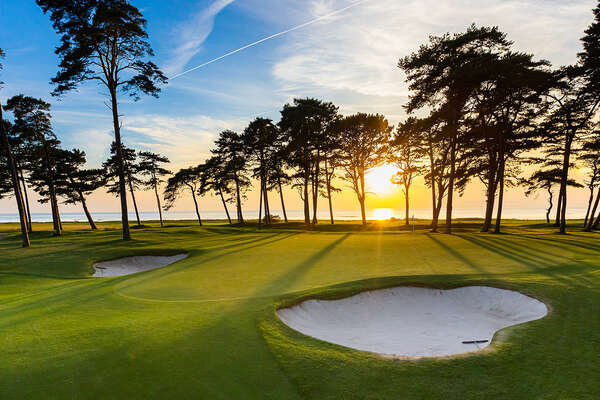 Women golfers walking along a seaside fairway at Barsebäck Ocean Course, Sweden.
